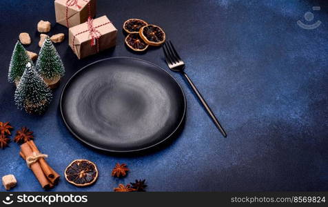 A piece of fresh delicious cake with nuts and chocolate on a black plate against a dark blue background. Desserts and sweets to the dinner table. A piece of fresh delicious cake with nuts and chocolate on a black plate against a dark blue background