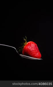 A piece of fruit in a spoon