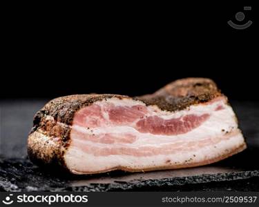 A piece of homemade pork lard. On a black background. High quality photo. A piece of homemade pork lard. 
