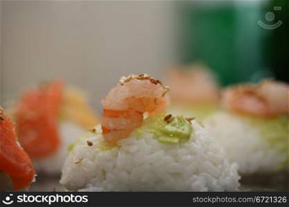 A piece of nigirisushi: rice with a scrimp and wasabi topping