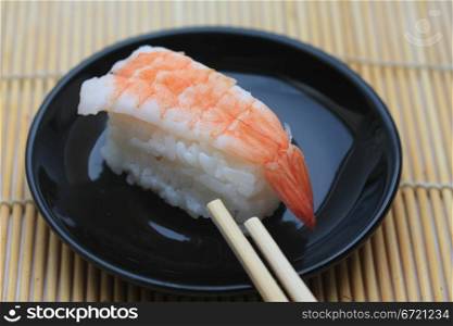 A piece of nigirisushi, rice with a scrimp topping