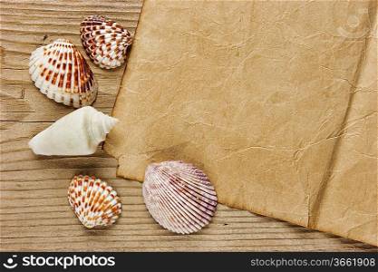 a piece of paper and seashells on old wooden board