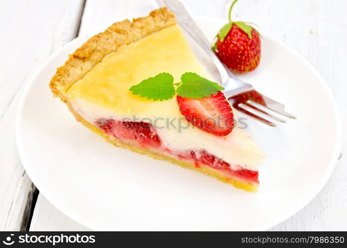 A piece of strawberry pie with cream sauce, fork, strawberry, mint in white plate on the background light wooden boards