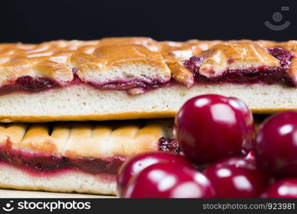 a piece of traditional cherry cake made from wheat flour and red cherry berries, cut into pieces with a layer of cherry jam. a piece of traditional cherry cake
