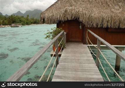 A pier with a thatched roof structure supported by stilts, Moorea, Tahiti, French Polynesia, South Pacific