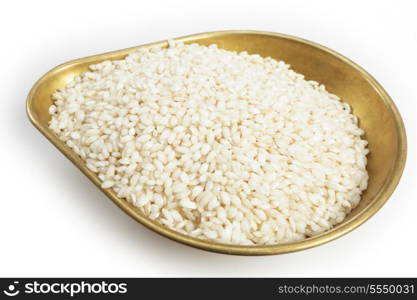 A pile of 460grams (one pound) of arborio Italian rice in the weighing pan from a set of scales, with a light shadow over white.