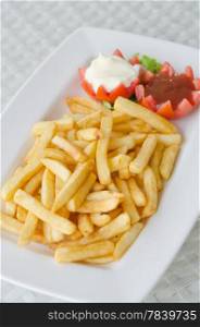 a pile of appetizing french fries on white plate with sauce. french fries