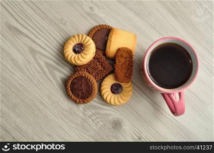 A pile of biscuits with a pink mug filled with coffee. Top view.