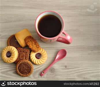 A pile of biscuits with a pink mug filled with coffee. Top view.