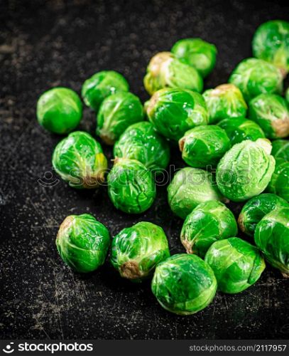 A pile of Brussels cabbage on the table. On a black background. High quality photo. A pile of Brussels cabbage on the table.