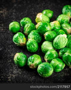 A pile of Brussels cabbage on the table. On a black background. High quality photo. A pile of Brussels cabbage on the table.