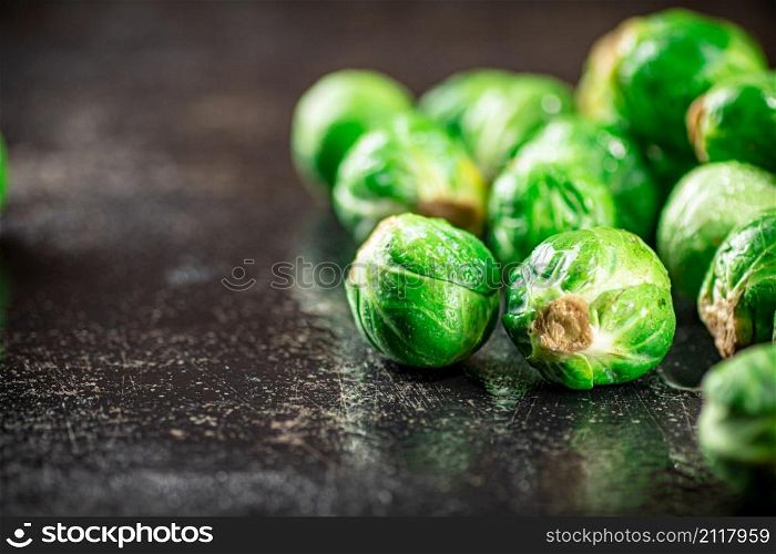 A pile of Brussels cabbage on the table. On a black background. High quality photo. A pile of Brussels cabbage on the table.