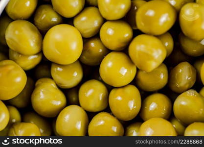 A pile of canned green peas. Macro background. Pea texture. High quality photo. A pile of canned green peas.