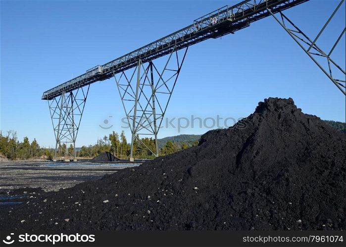 A pile of coal dust and the steel infrastructure for loadout facilities at a coal mine