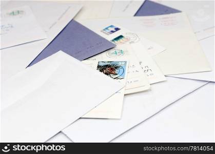 A pile of envelops and postcards, bills on a doormat.
