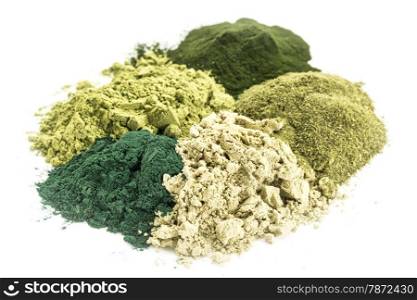 a pile of five healthy green dietary supplement powders (spirulina, chlorella, wheatgrass, kelp and moringa leaf)
