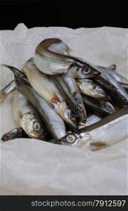 A pile of fresh capelin in parchment paper