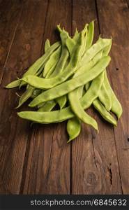 A pile of fresh green beans on table. Green runner beans. Top vi. A pile of fresh green beans on table. Green runner beans. Top view