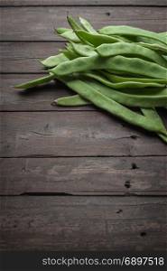 A pile of fresh green beans on table. Green runner beans. Top view