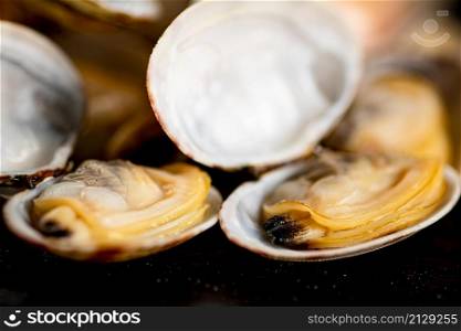 A pile of fresh vongole on the table. On a black background. High quality photo. A pile of fresh vongole on the table.