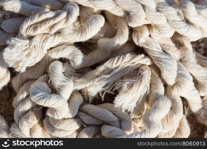 A pile of old damaged tangled rope abandoned on the ground