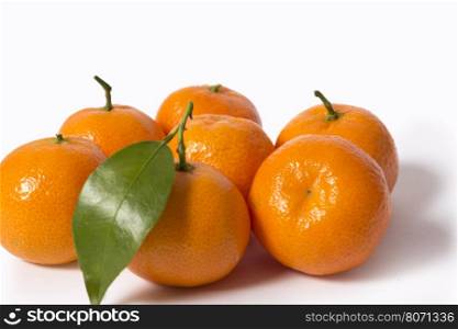 A pile of ripe tangerines with leaves isolated on white background without shadows.. Tangerines