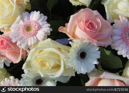 A pink and white floral arrangement with roses and gerberas