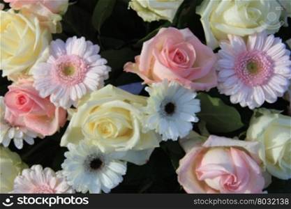 A pink and white floral arrangement with roses and gerberas