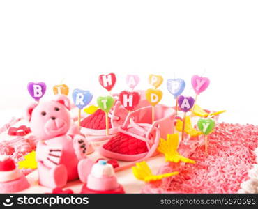 "A pink birthday cake with "Happy birthday" candles"