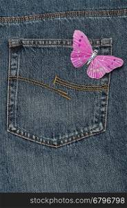 A pink butterfly made out of silk displayed on a back pocket of a denim jean