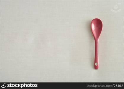 A pink glass teaspoon isolated on a white background