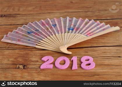 A pink hand fan with 2018 for the chinese new year