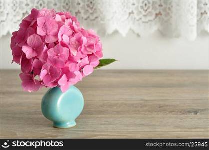 A pink Hydrangea in a blue vase