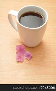A pink Hydrangea with a white mug