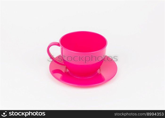 a pink plastic cup with saucer on white background. pink plastic cup with saucer on white background