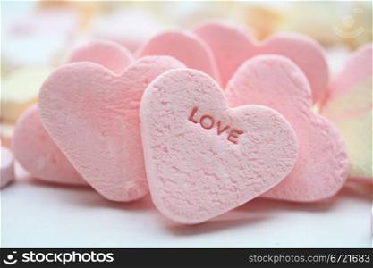 A pink valentine candy heart with the word love