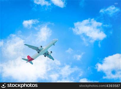 A plane flying in the blue sky with white clouds