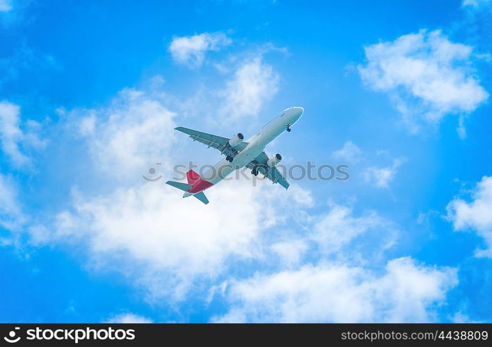 A plane flying in the blue sky with white clouds