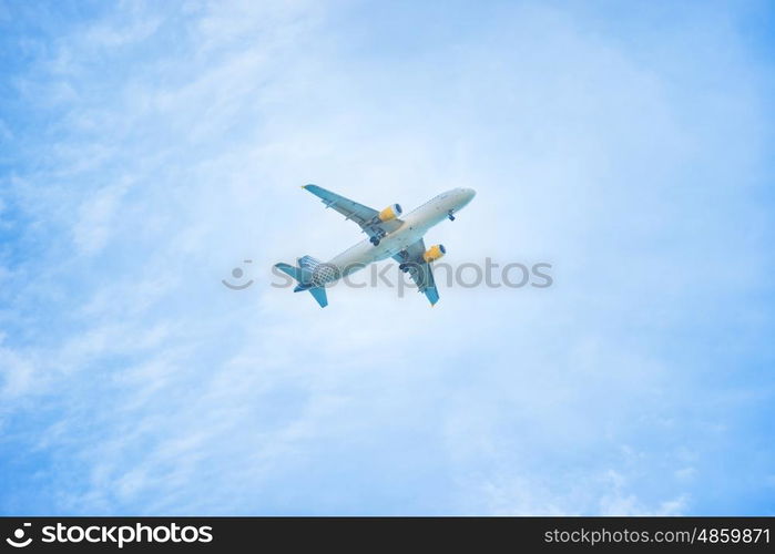 A plane flying in the blue sky with white clouds