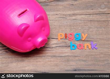 A plastic piggy bank on a table with the words piggy bank