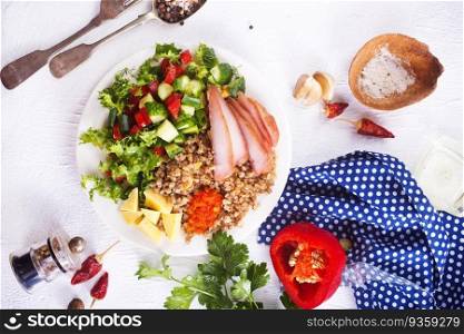 A plate of buckwheat with meat, salad , cheese on white backgrond