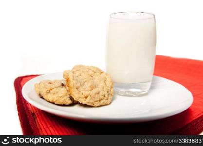 A plate of chocolate chip cookies and a tall glass of milk