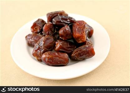 A plate of dates, eaten at fast-breaking (suhour) in Ramadan, on a tablecloth.