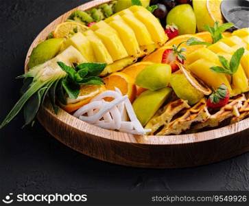 A plate of fruit assorted on black stone