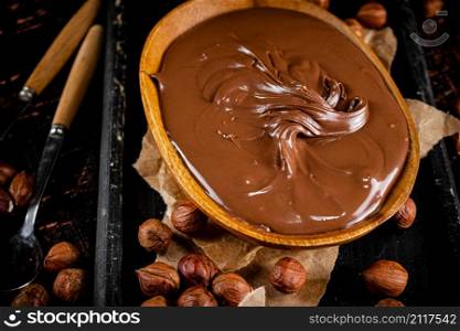 A plate of hazelnut butter on a cutting board. Against a dark background. High quality photo. A plate of hazelnut butter on a cutting board.