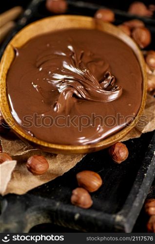 A plate of hazelnut butter on a cutting board. Against a dark background. High quality photo. A plate of hazelnut butter on a cutting board.