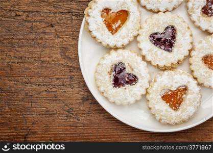 a plate of heart biscuit cookies against grunge wood background