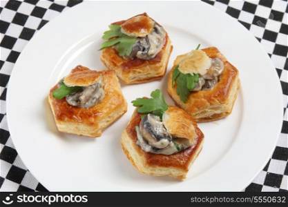 A plate of homemade mushroom vol-au-vents garnished with a parsley leaf