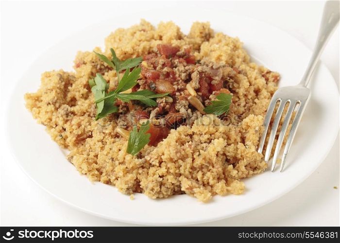 A plate of Lebanese burghul bi banadoura, or cracked wheat with tomatoes. The dish incorporates onion, minced meat and pine nuts, along with the burghul or bulgar wheat.