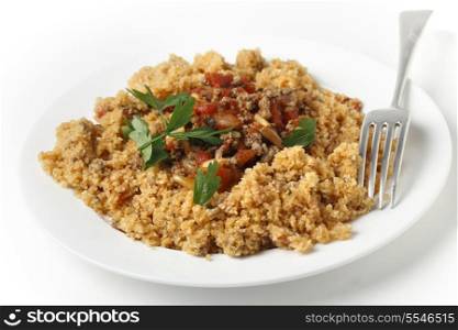 A plate of Lebanese burghul bi banadoura, or cracked wheat with tomatoes. The dish incorporates onion, minced meat and pine nuts, along with the burghul or bulgar wheat.